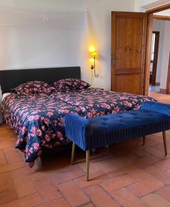 a bedroom with a bed with a blue comforter at Casa le Rondini Toscana in Bucine