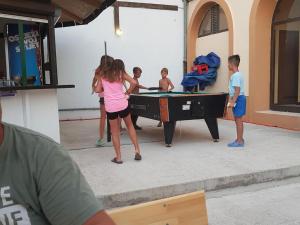 a group of children standing around a pool table at M&M Mobile home in Privlaka