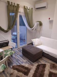 een woonkamer met een bed en een raam bij Panda apartment in Thessaloniki
