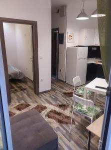een woonkamer met een tafel en stoelen en een keuken bij Panda apartment in Thessaloniki