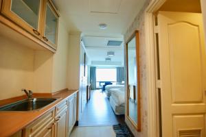 a kitchen with a sink and a room with a bed at 台中自由行 in Taichung