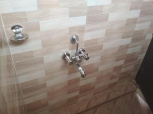 a bathroom with a shower fixtures on a wooden floor at Sri Abbirami Lodge in Kumbakonam