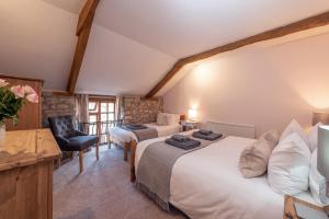 1 dormitorio con 2 camas, escritorio y silla en Somerset Country Escape - Luxury barns with hot tubs en Hatch Beauchamp