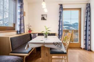 d'une salle à manger avec une table, des chaises et une fenêtre. dans l'établissement Urlaub auf dem Bauernhof Hallerhof, à Villandro