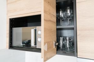 a cupboard with wine glasses in it at Stay in Cervinia Deluxe Apartment in Breuil-Cervinia
