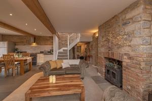 - un salon avec une cheminée et un mur en pierre dans l'établissement Somerset Country Escape - Luxury barns with hot tubs, à Hatch Beauchamp