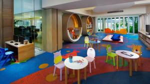 a childrens room with tables and chairs and a play area at Amari Phuket in Patong Beach