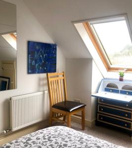 a bedroom with a chair and a desk and a window at Streamside B and B with Parking in Drom dhá Liag