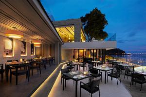 a restaurant with tables and chairs on a balcony at Amari Phuket in Patong Beach
