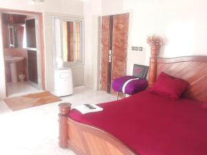 a bedroom with a large bed with a red blanket at Bienvenue CHEZ VOUS in Dakar
