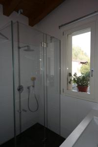 y baño con ducha de cristal y ventana. en Casa Franka Garda Lake View, en Toscolano Maderno