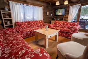 ein Wohnzimmer mit roten Sofas und einem Tisch in der Unterkunft Chalet Vancouver in Donovaly