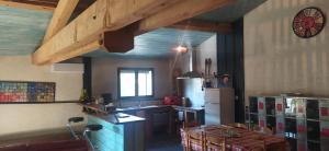 a kitchen with a refrigerator and a table in it at L'Atelier in Rouffiac-dʼAude