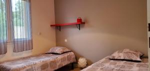 a bedroom with two beds and a red shelf on the wall at Elsanais in Figari
