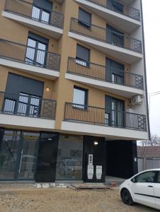 an apartment building with a car parked in front of it at Room Jacuzzi “ATHENA” in Subotica