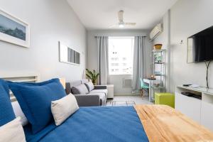 a bedroom with a blue bed and a couch at Apartamento silencioso em Copacabana | SL 363/1004 in Rio de Janeiro