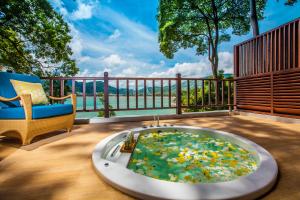 a bath tub sitting on a deck with a chair at Amari Phuket in Patong Beach