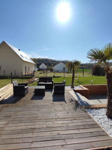 Una pasarela de madera con bancos y palmeras en un parque en Appartement 100m2, indépendant dans notre maison, en Garennes-sur-Eure