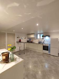 una gran cocina blanca con mesa y electrodomésticos en Appartement 100m2, indépendant dans notre maison en Garennes-sur-Eure