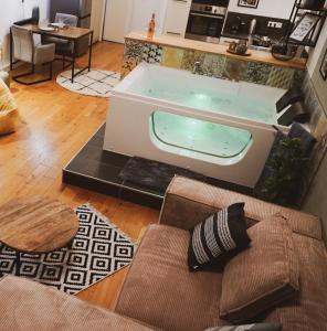 eine Badewanne im Wohnzimmer mit Sofa in der Unterkunft Stilvolles City-Loft mit privatem Whirlpool in Trier