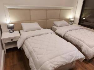 two beds sitting next to each other in a room at Exquisite Modern 2-bedroom Rental Unit in Amman