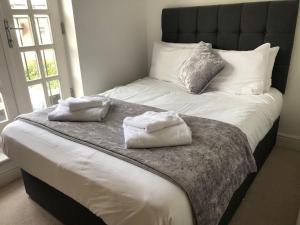 a bed with two towels sitting on top of it at Blue Sky Apartments@Guildford Town Centre in Guildford