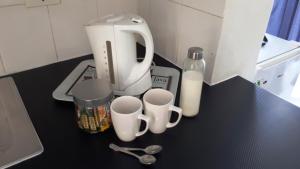a counter with two cups and two spoons and a blender at 13th Avenue Guesthouse Benoni in Benoni