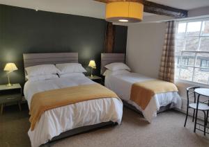 a bedroom with two beds and a window at The Fox in Much Wenlock