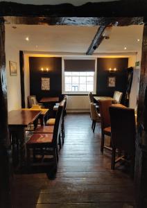 a dining room with tables and chairs and a window at The Fox in Much Wenlock