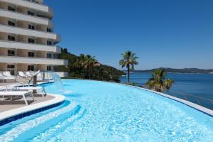 une piscine avec vue sur l'océan et un hôtel dans l'établissement RMH Lopud Lafodia Resort & Wellness, à Lopud