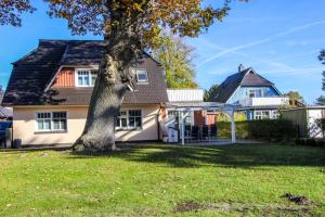 a house with a tree in the yard at Sanddornperle in Prerow