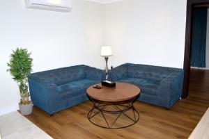 un divano blu in soggiorno con tavolo di Sultanate Jazan a Jazan