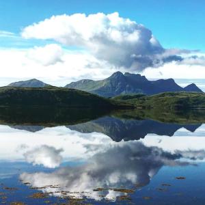 un riflesso di una montagna in un corpo idrico di Spectacular Highland Cottage Overlooking the Sea a Tongue