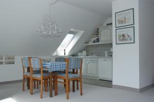 a kitchen with a table and chairs and a chandelier at Haus Burmeister in Tinnum