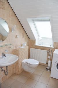 La salle de bains est pourvue d'un lavabo, de toilettes et d'une fenêtre. dans l'établissement Haus Burmeister, à Tinnum