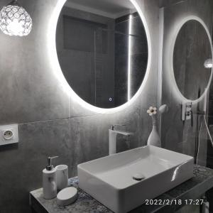 a bathroom with a white sink and a mirror at Harmonica Studio in Nowy Sącz