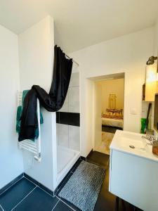 a white bathroom with a sink and a tub at L'appartement du Temple à Vienne in Vienne