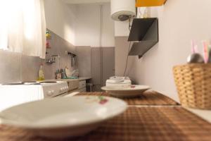 a kitchen with two white plates on a wooden table at Nice Apartment Near City Center in Athens