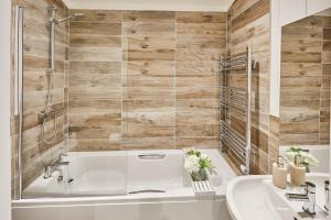 La salle de bains est pourvue d'une baignoire blanche et d'un lavabo. dans l'établissement Host & Stay - Eller Beck, The Cabin In The Woods, à Egton