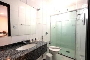 a bathroom with a sink and a toilet and a shower at Italian Palace Hotel Rede Carlton in Três Corações