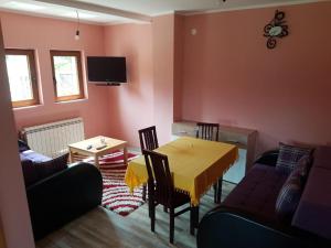 una sala da pranzo con tavolo, sedie e TV di Vila Tri Srca a Beserovina Altre 37 foto