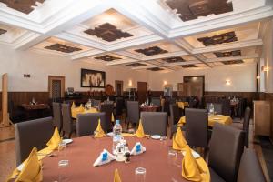 uma sala de jantar com mesas e cadeiras com guardanapos amarelos em HOTEL DES THERMES em Tarmilet
