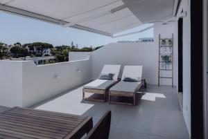 a balcony with two beds on a white wall at Casa Balaia 70 in Albufeira