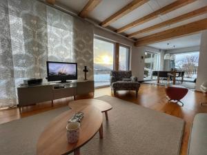 a living room with a tv and a couch and a table at Haus Sonnenweg in Mariapfarr