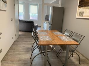 a dining room table with chairs and a refrigerator at Neurenovierte FeWo Harztor in Nordhausen +11 photos