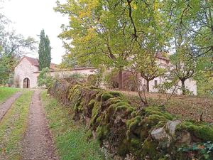 eine Steinmauer vor einem Haus in der Unterkunft Les granges de l abbaye in Ginals