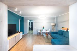 a living room with a blue couch and a tv at Central Chic Otopeni in Otopeni