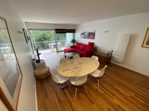 a living room with a table and a red couch at Appart 6 pers au Bord de la Mer in Le Pouliguen