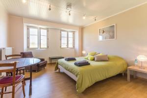 a bedroom with a bed and a table and chairs at Gîte « les roblets » in Bougey