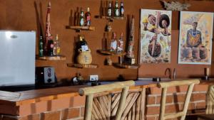 un bar con botellas en la pared y una nevera en Africa Safari Maasai Boma en Serengeti